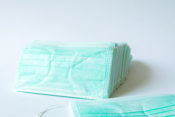 Fototapeta premium Green color Medical mask for protection against flu and other diseases. Surgical protective mask. Medical respiratory bandage face on isolate white background. prevention of the spread of virus