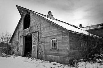 An abandon, weathered, gray barn on a former Midwest homestead.