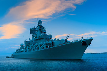 Fototapeta na wymiar Warship. A ship with a lot of guns on board. Naval forces. Ship for military operations. Sea ship near the city. Transplanting people from vessel to vessel. Concept - Russian arms. Ocean
