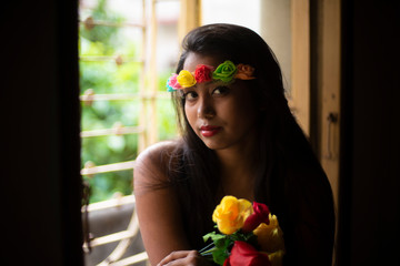Portrait of an Asian/Japanese/Korean brunette young girl in greenish blue  western dress with floral head band front of a window inside of a room. Fashion and cosplay photography. - Powered by Adobe