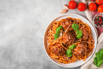 Homemade meatballs with pasta spaghetti, tomato sauce, parmesan cheese and basil on concrete background. top view