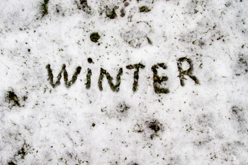The word Winter is written on white snow. Winter background the onset of winter. First snow.