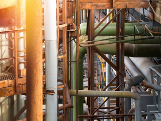 Tangle of pipes. Concept of complexity of petrochemical industry communications. Pipe weaving of various diameters with expansion joints and flanges with sunflare