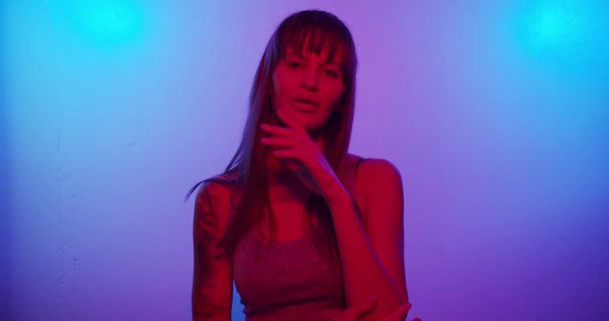 Fashion model girl Turns to the camera and looks in neon light