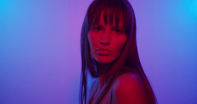 Fashion model girl Turns to the camera and looks in neon light