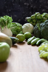 grünes Gemüse und Obst auf brauner Platte aus Holz