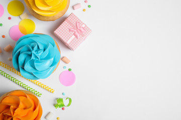 Flat lay composition with colorful birthday cupcakes on white background. Space for text