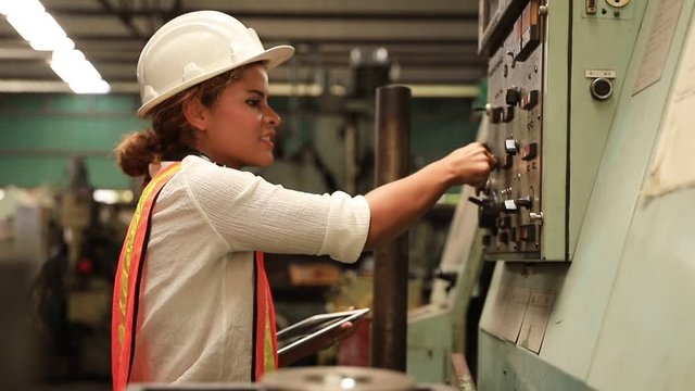 Industry maintenance engineer woman dark skin wearing uniform and safety helmet under inspection and checking production process on factory station by tablet. Industry, Engineer, construction concept.