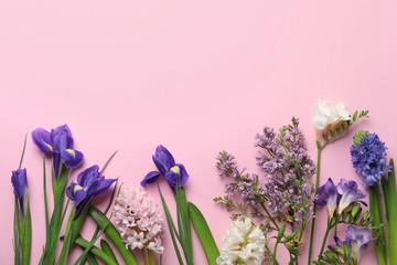 Flat lay composition with spring flowers on pink background. Space for text
