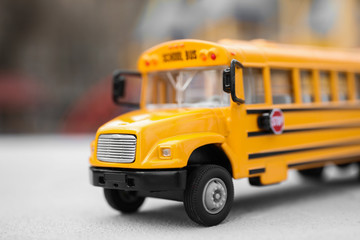Yellow toy school bus against blurred