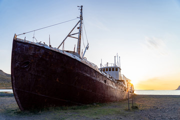 An out-of-the-way whaling ship that wrecked on the beach to Latrabjarg during sunset - obrazy, fototapety, plakaty