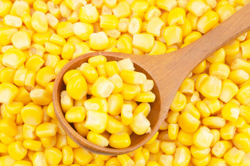 Canned corn with wooden spoon