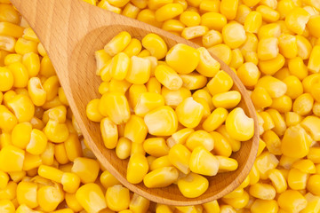 Canned corn with wooden spoon