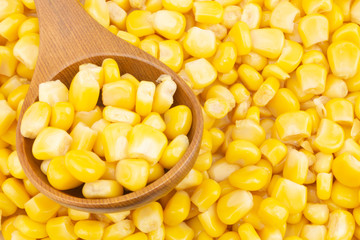 Canned corn with wooden spoon