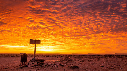 Garbage bin beneath intensely colored sunset