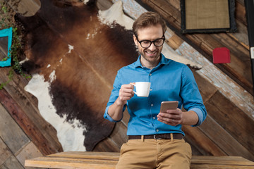 Happy model laughing, holding coffee cup and phone