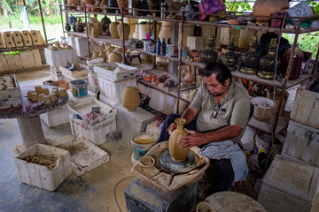 Local craftsman demonstrates on making traditional clay jar called 