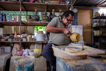 Local craftsman demonstrates on making traditional clay jar called 