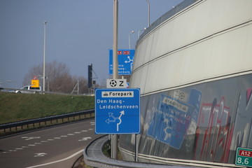 Blue and white direction sign at junction on the A12 The Hague Leidschenveen, industrial area Forepark and football stadium south