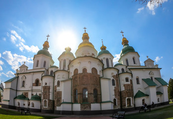 Fototapeta na wymiar St Sophia's Cathedral in Kiev, Ukraine seen from the front. The cathedral is white with green rooftops and golden turrets. Complex building, consisting of many smaller rooftops and towers.
