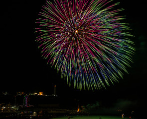 Beautiful fireworks in Santa Maria di Leuca, on the night of August 15th, in the summer holidays. Flashes of the colored fires are reflected on the sea. Boats watch the show. Puglia, Salento, Italy.