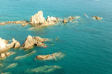 Piraguistas rodeando rocas cerca de la orilla