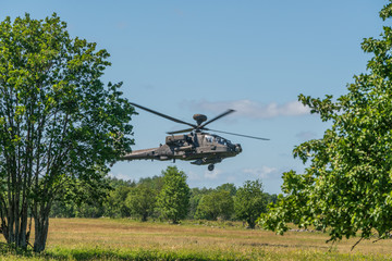 Fototapeta na wymiar Apache in combat. Helicopter battle training, low flight in natural airfield on Suur-Pakri island, Estonia, Europe.