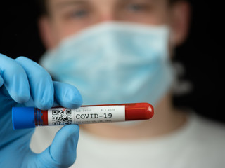 Test tube sample Coronavirus test in hand or researcher in rubber glove, yound researcher in the...