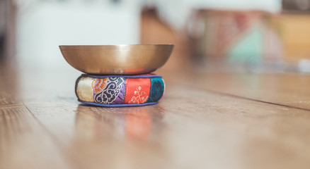 Tibetan singing bowl on a rustic wooden floor. Instrument for mediation and message.