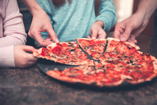 Family Eating Pizza At Home