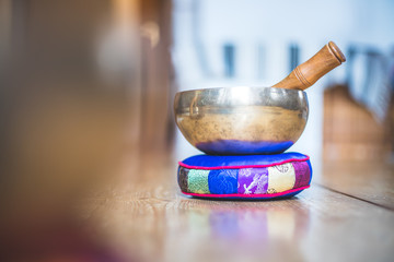 Tibetan singing bowl on a rustic wooden floor. Instrument for mediation and message.