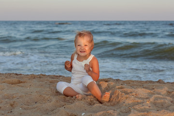Girl frolics in the sand on the seashore.