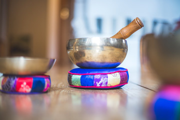 Tibetan singing bowl on a rustic wooden floor. Instrument for meditation and message.