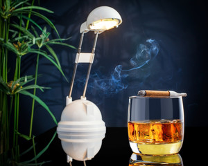glass of whiskey on ice, with cigar and energy saving light