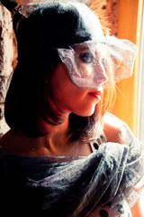 Vintage party. Portrait of a beautiful woman in a hat with a veil.