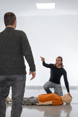 Man teaching cardiopulmonary resuscitation with a dummy on a white background. Notifying people around to call emergencies.