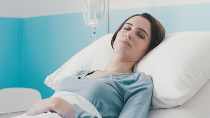 Young female patient lying in bed at the hospital