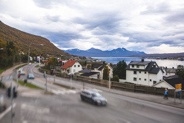 Fototapeta na wymiar View of Tromso, with cathedral, Tromso Bridge, Tromsoya island, embankment and scenery beyond the city, Troms og Finnmark county, Norway, summer day