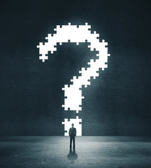 Businessman looking on big question mark.