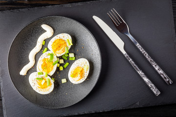 boiled eggs on black plate and background