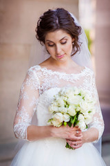 Beautiful Bride with Beautiful Lace Dress and White Roses Bouquet 