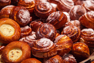 Hot sweet buns with powdered sugar. Lying on the counter in the store