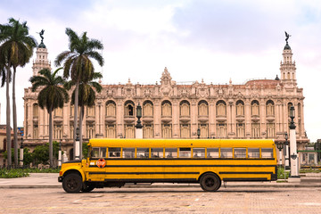 Fototapeta na wymiar old yellow school bus in front of the grand theatre in havana cuba