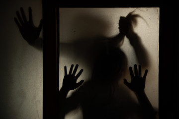 The silhouette of a human in front of a door at night.Scary scene Halloween concept of blurred silhouette,Ghost movies poster