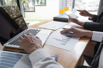 Two business people are discussing about business graph on the table in the office room