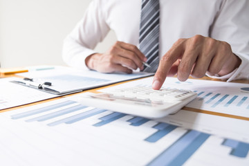 Businessman using calculator on the table in the office room