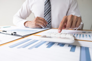 Businessman using calculator on the table in the office room