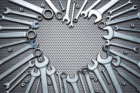 Concept - professional men's holiday. Chrome wrenches on a steel workbench in the shape of a heart. Copy space.