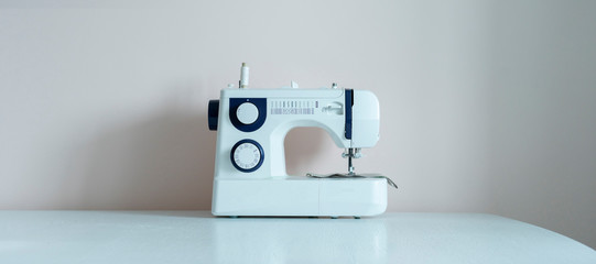 a simple sewing machine on the shelf against the wall isolated, home supplies wide long banner