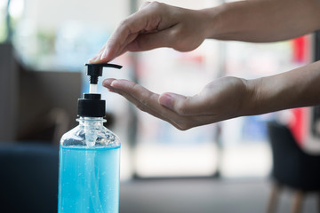 Woman hands using wash hand sanitizer gel dispenser, against Novel coronavirus or Corona Virus...